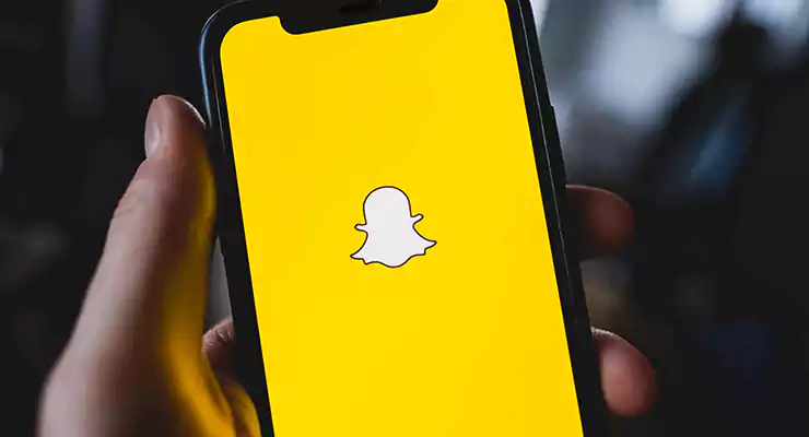 logotipo do aplicativo snapchat na tela do smartphone na mão
