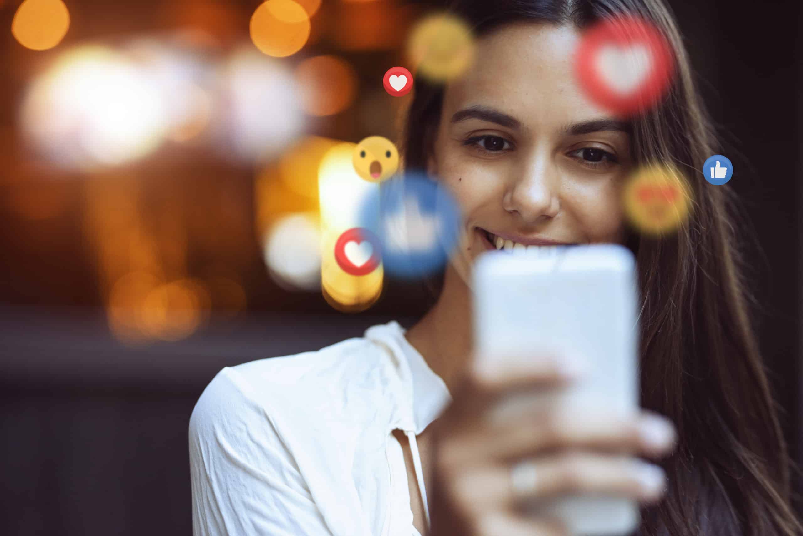 ddicas-para-criar-um-post-de-sucesso-no-facebook mulher no celular que mostra reações do facebook