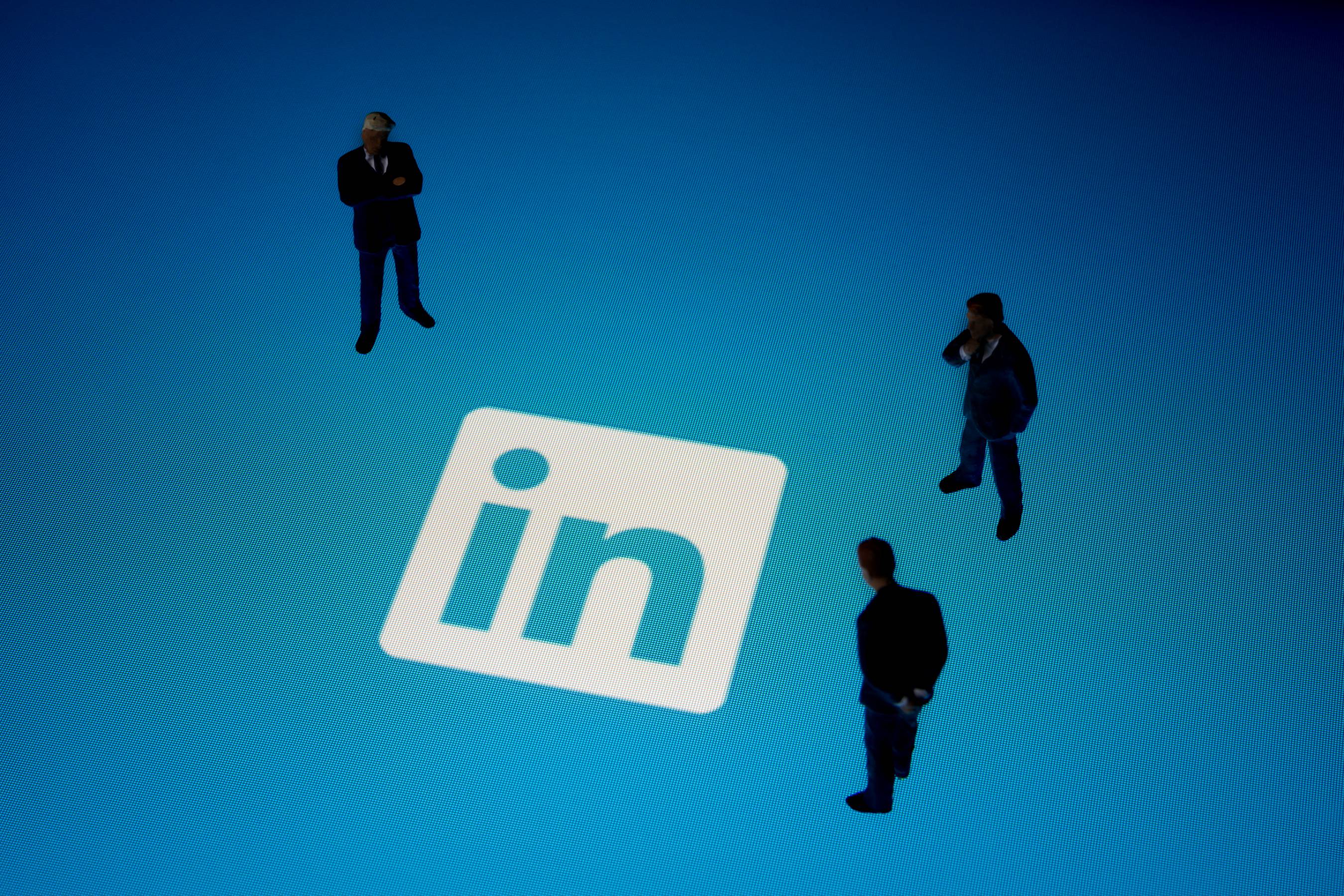 confira-dicas-de-marketing-no-linkedin homens encarando a logo do linkedin