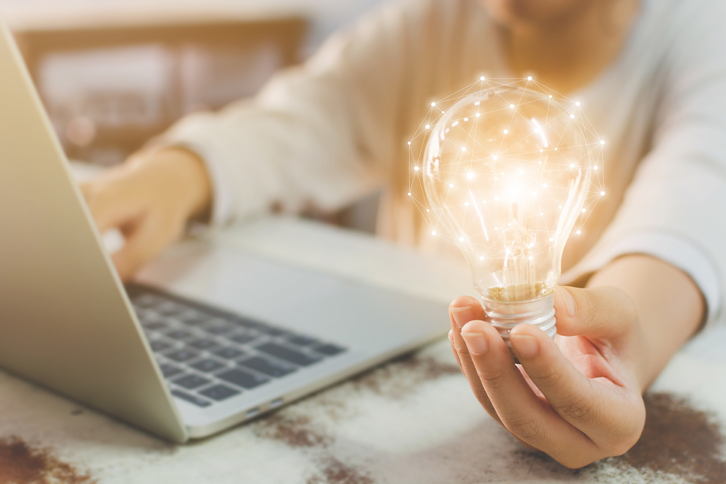 marketing-digital-cases-de-sucesso-para-voce-se-inspirar.jpg mulher no computador segurando uma lâmpada. Conceito de ideia e inspiração