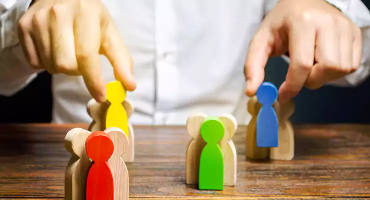 a-relevancia-do-publico-alvo-para-o-sucesso-do-seu-conteudo Grupos de pessoas de madeira multicoloridas e empresário. Para representar o conceito de público-alvo..