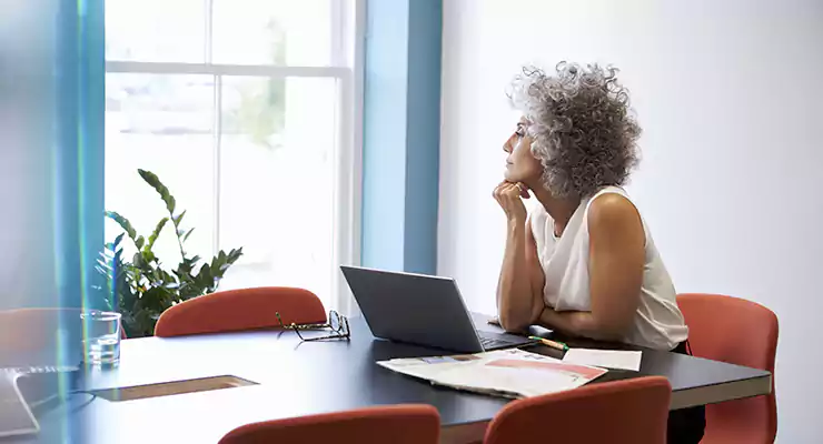como-escolher-as-principais-palavras-chave-do-seu-negocio mulher mais velha pensativa em frente ao computador