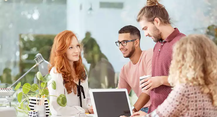 pessoas de uma empresa reunidas em volta do computador 