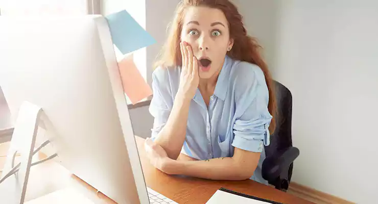 mulher surpresa na frente do computador