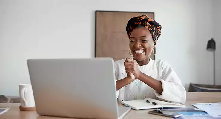 mulher feliz olhando pro computador