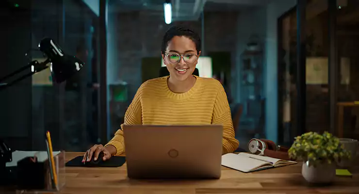 mulher em escritório olhando as redes sociais pelo computador