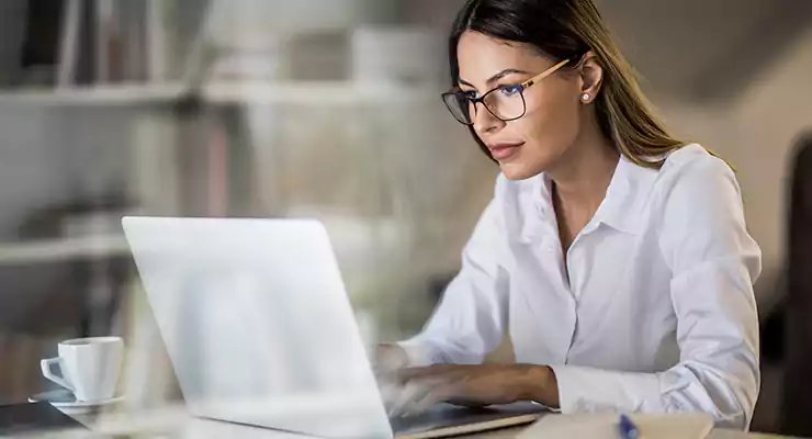 -ferramentas-para-ajudar-na-estrategia-de-marketing-de-conteudo Empresária mexendo no computador olhando ferramentas de marketing de conteúdo