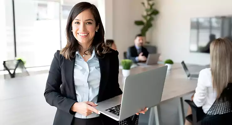 produtor-de-conteudo-digital-como-contratar-um mpreendedora sorridente com laptop em uma sala de reunião