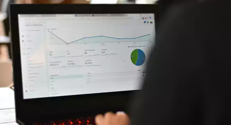 como-adicionar-um-site-no-google-analytics-descubra-aqui Trabalhador verificando o visitante de tráfego do site no Google Analytics